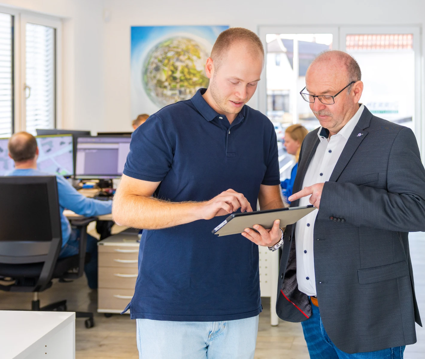 Inhaber Lukas Peter und Torsten Peter besprechen sich mit einem Tablet